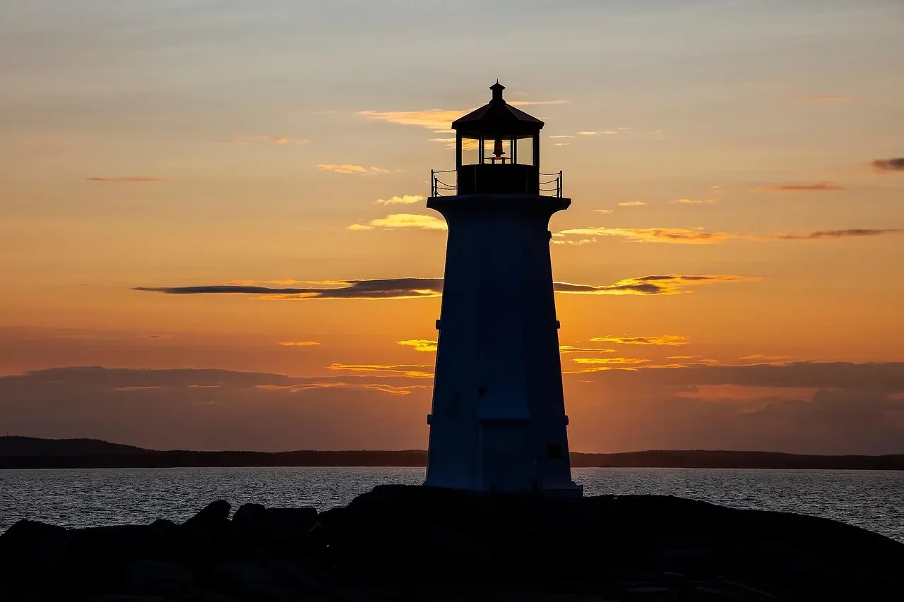 The lighthouse at Peggys Cove silhouetted against the sunset