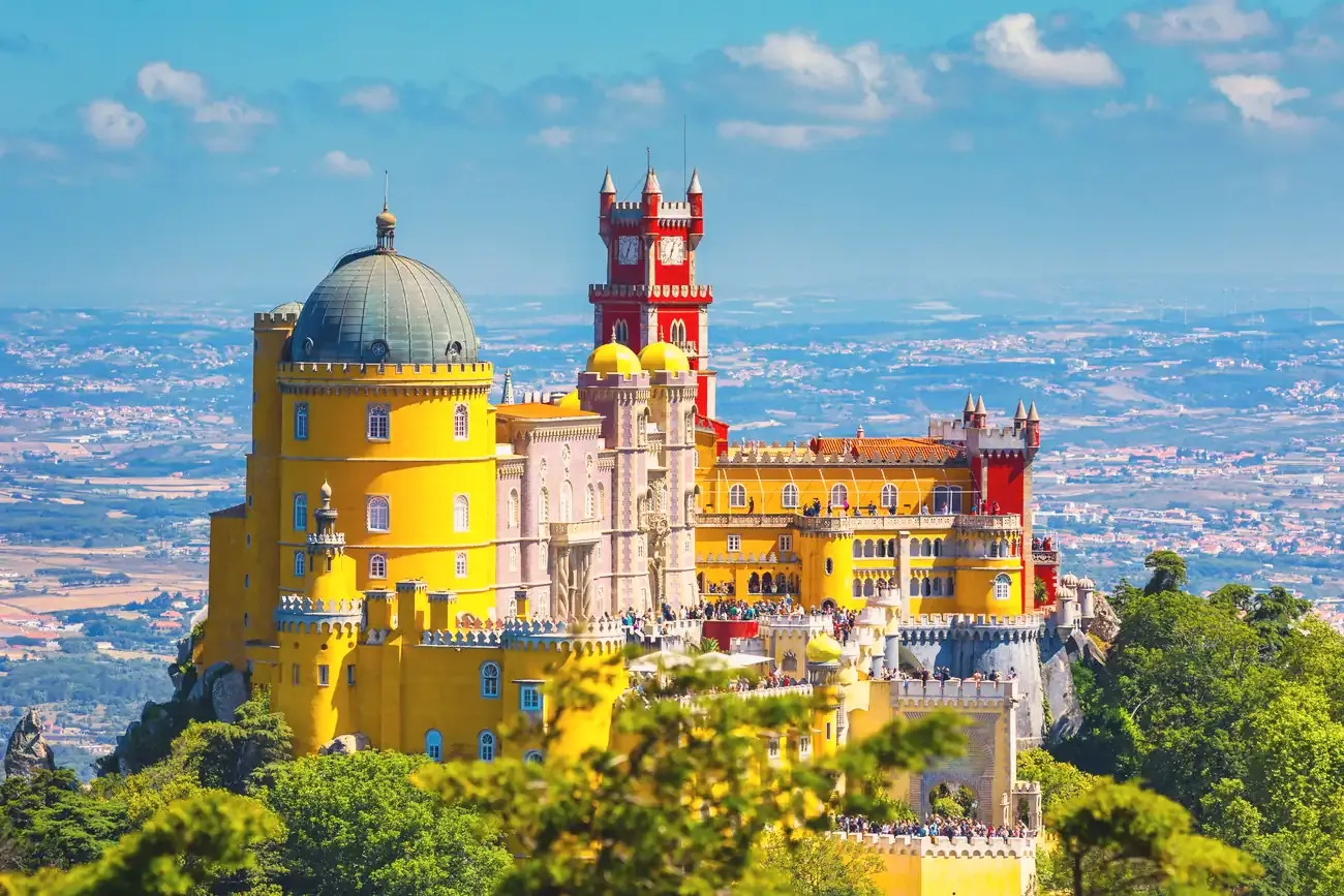 The yellow and red Pena Palace on its wooded hilltop above Sintra, Portugal