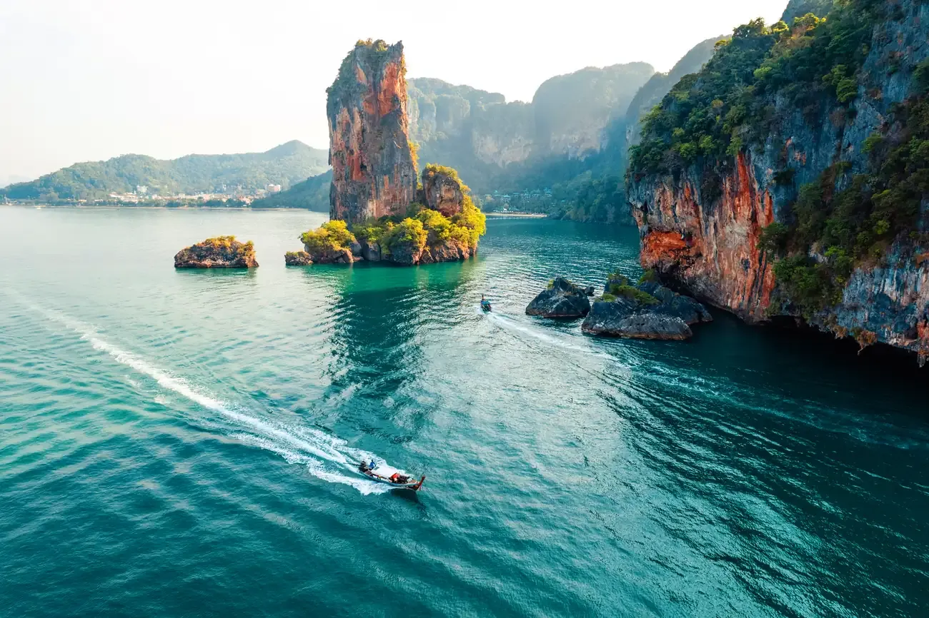 Limestone islands and a longtail boat in the turquoise Andaman Sea, Phuket
