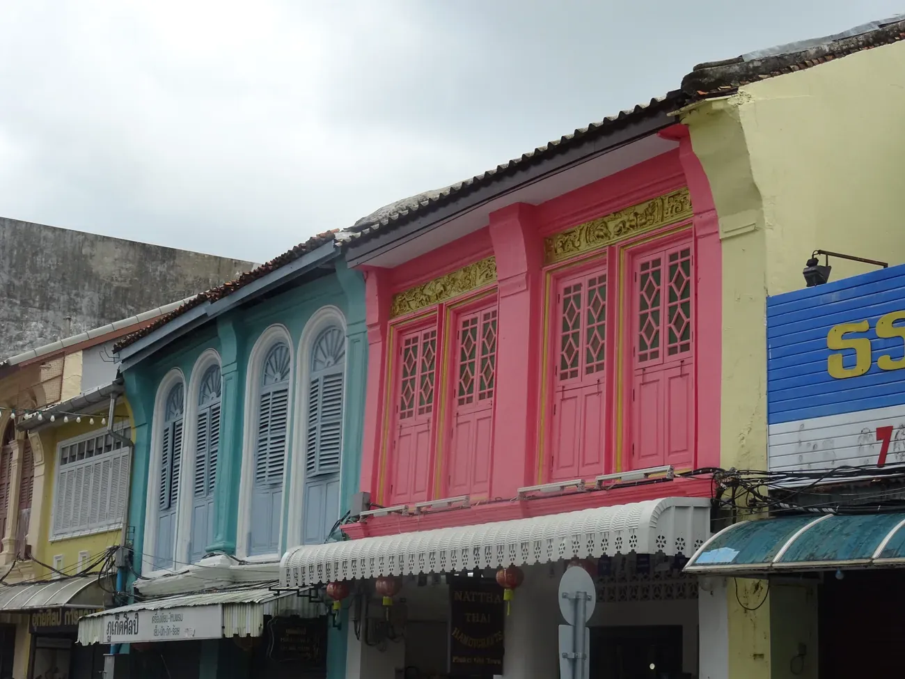 Colourful shophouse facades with gilded shutters in Old Phuket Town
