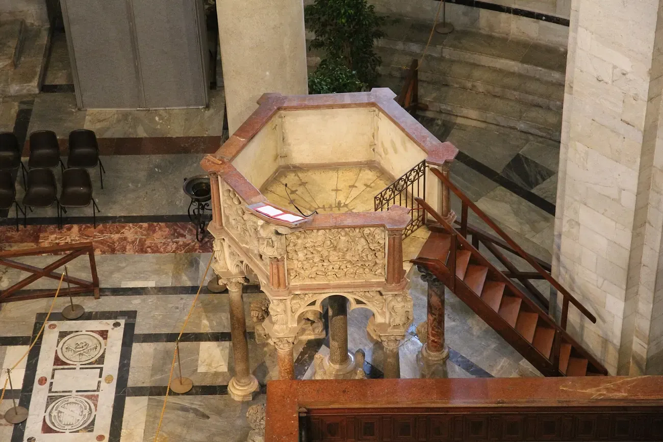 The octagonal marble baptismal font inside the Pisa Baptistery