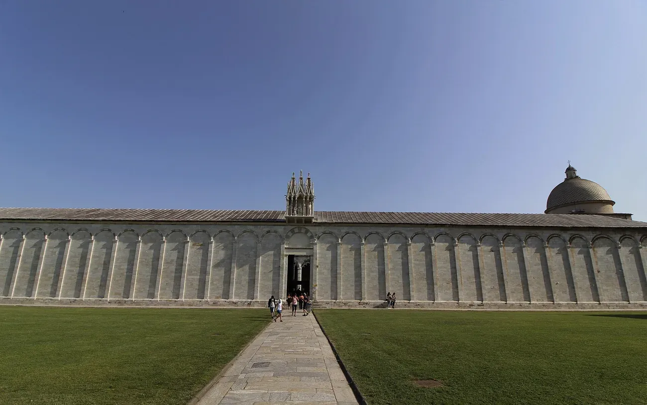 The long white marble outer wall of the Camposanto Monumentale in Pisa