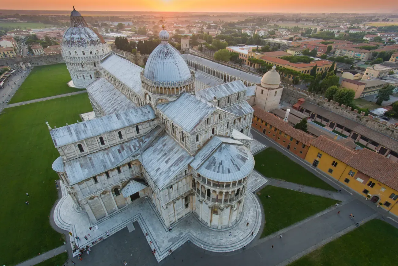 Close aerial view of the Pisa Cathedral's domes and rooftops in golden morning light