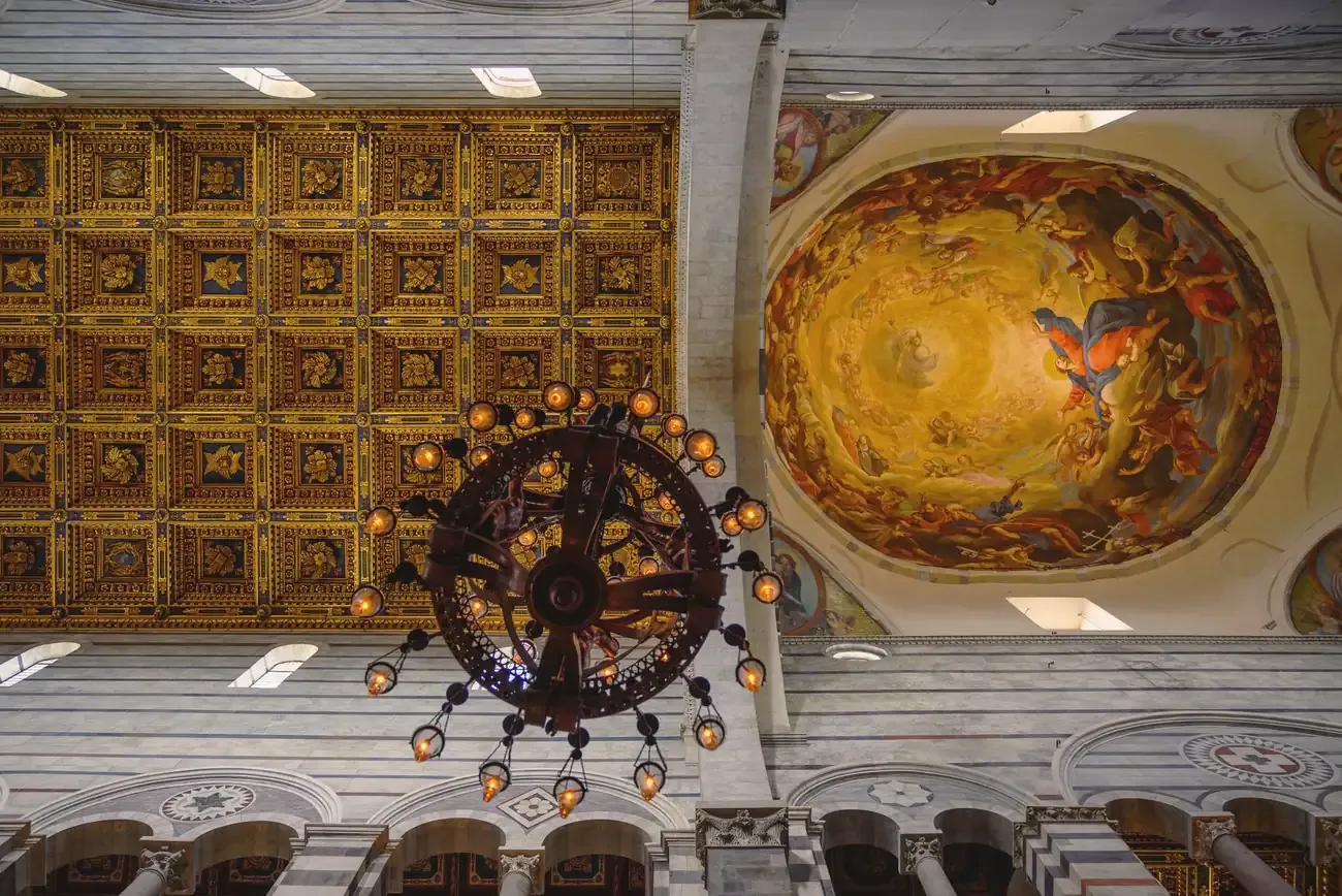 Gilded coffered ceiling and frescoed dome inside Pisa Cathedral