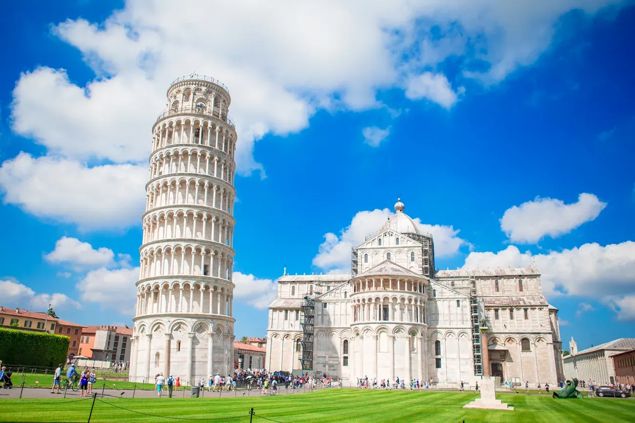 Wide view of Pisa's Duomo and the Leaning Tower with visitors in the Piazza dei Miracoli