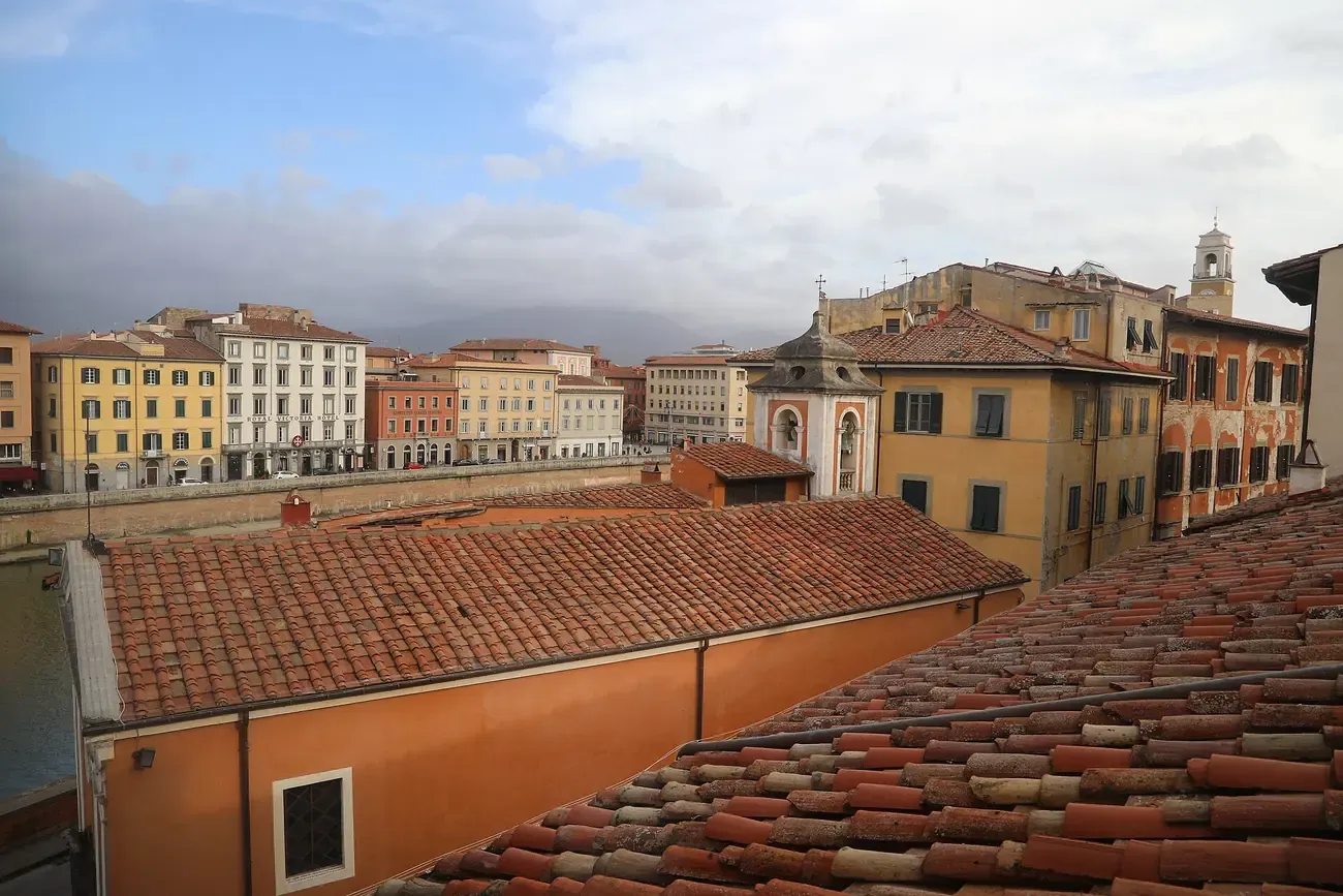 View over terracotta rooftops towards the Arno from Palazzo Blu in Pisa