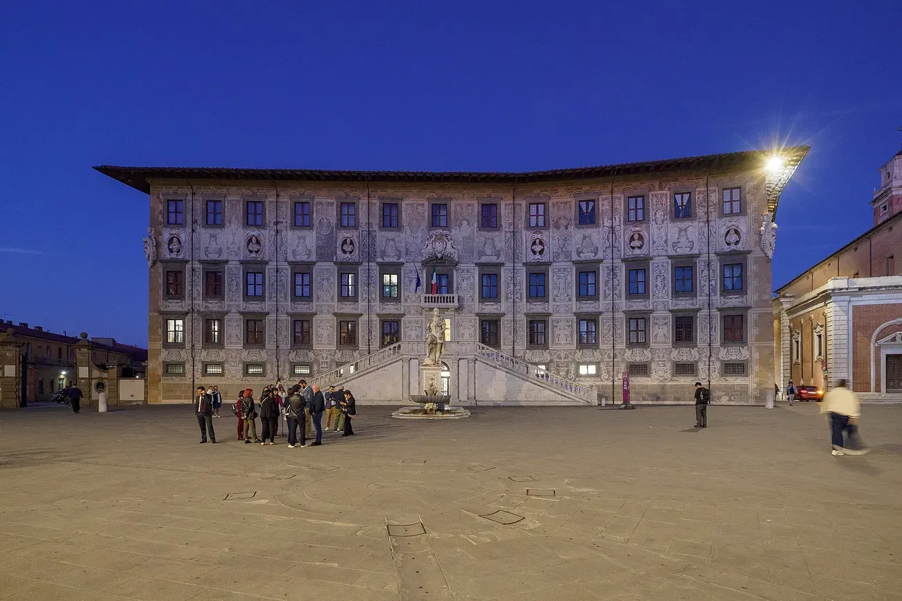 The Palazzo della Carovana lit up at dusk on Piazza dei Cavalieri in Pisa