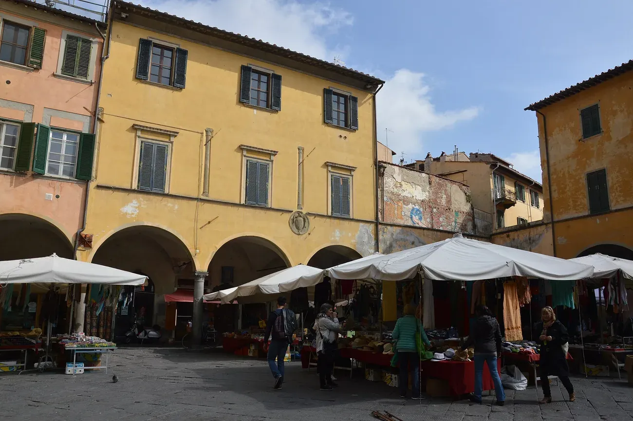 Market stalls under the arcaded loggia of Piazza delle Vettovaglie in Pisa