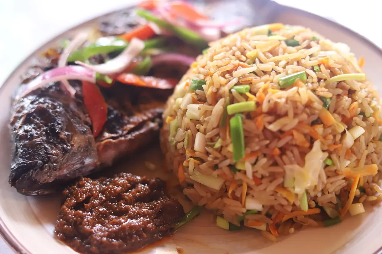 A plate of jollof rice served with fried fish