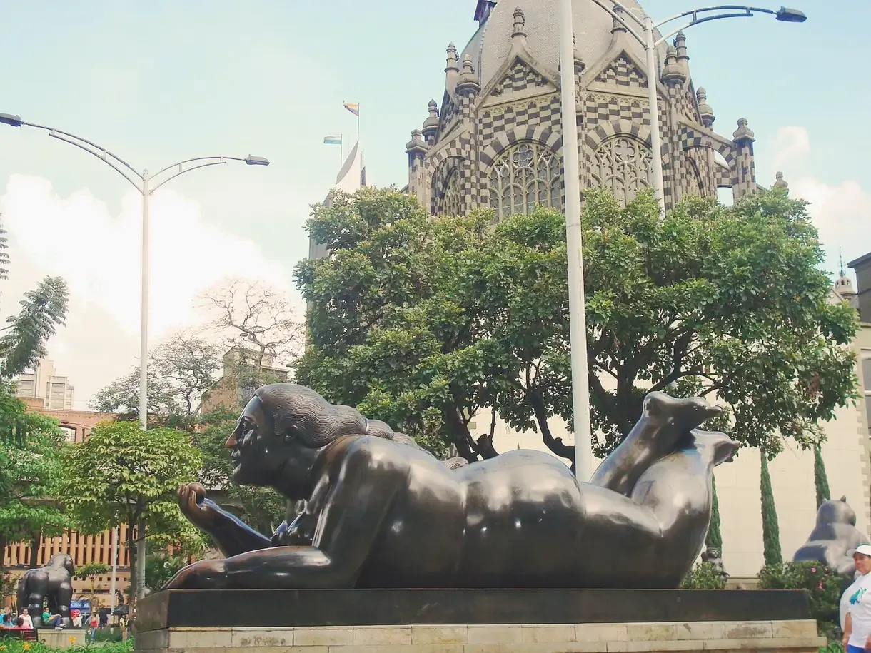 Fernando Botero's plump bronze sculptures on Plaza Botero, with the Rafael Uribe Uribe Palace of Culture behind, Medellin, Colombia