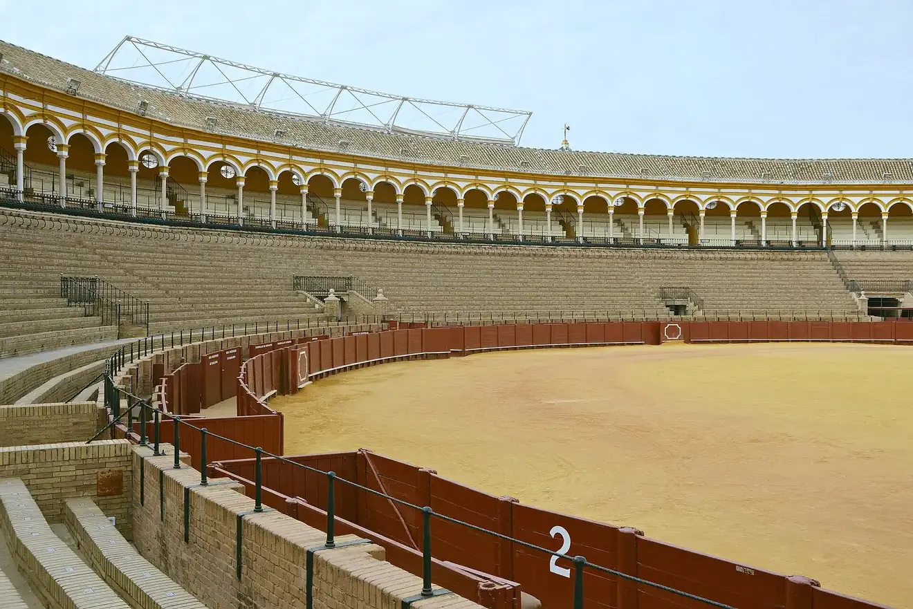 The sand ring and arcaded stands inside the Real Maestranza bullring in Seville
