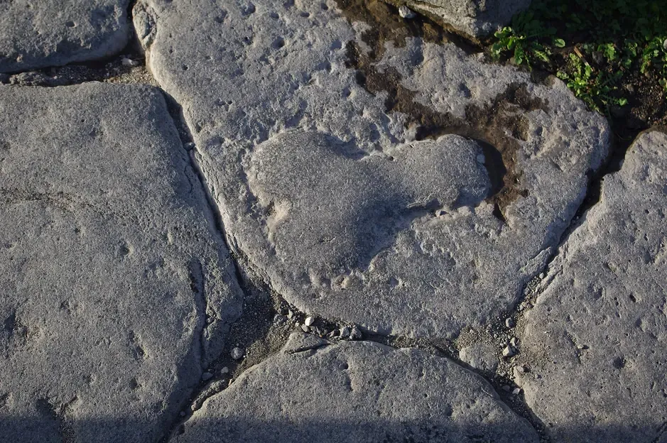 A carved phallic relief on a paving stone in a street of Pompeii