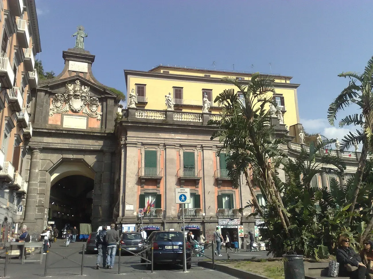 The 1625 Port'Alba gate seen from Piazza Dante in Naples with secondhand bookshops beside the entrance to the alley