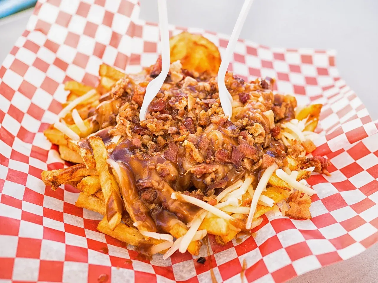 Poutine, french fries with cheese curds and gravy, in a paper tray