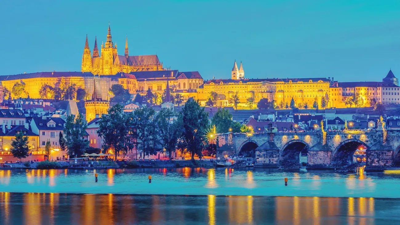 Prague Castle and Charles Bridge lit up and reflected in the Vltava