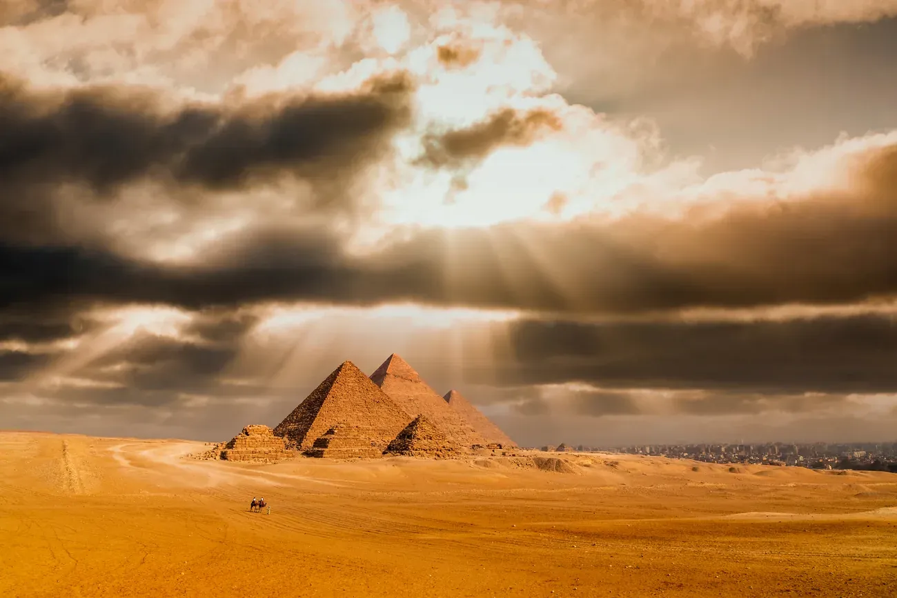 The Pyramids of Giza under a dramatic sunset sky near Cairo