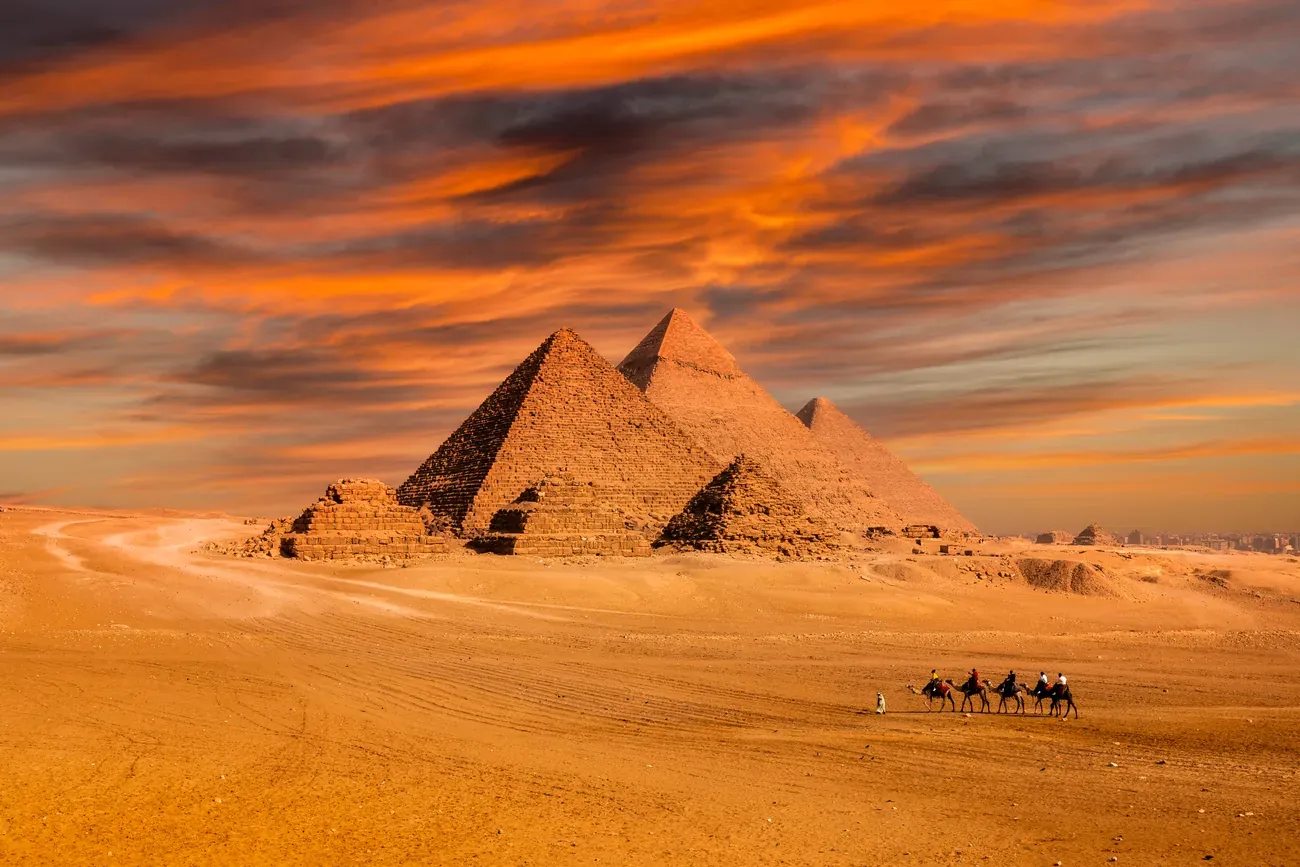 A camel caravan near the pyramids of Giza at sunset, Egypt