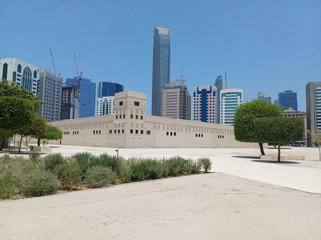 The white walls of Qasr Al Hosn against the towers of Abu Dhabi