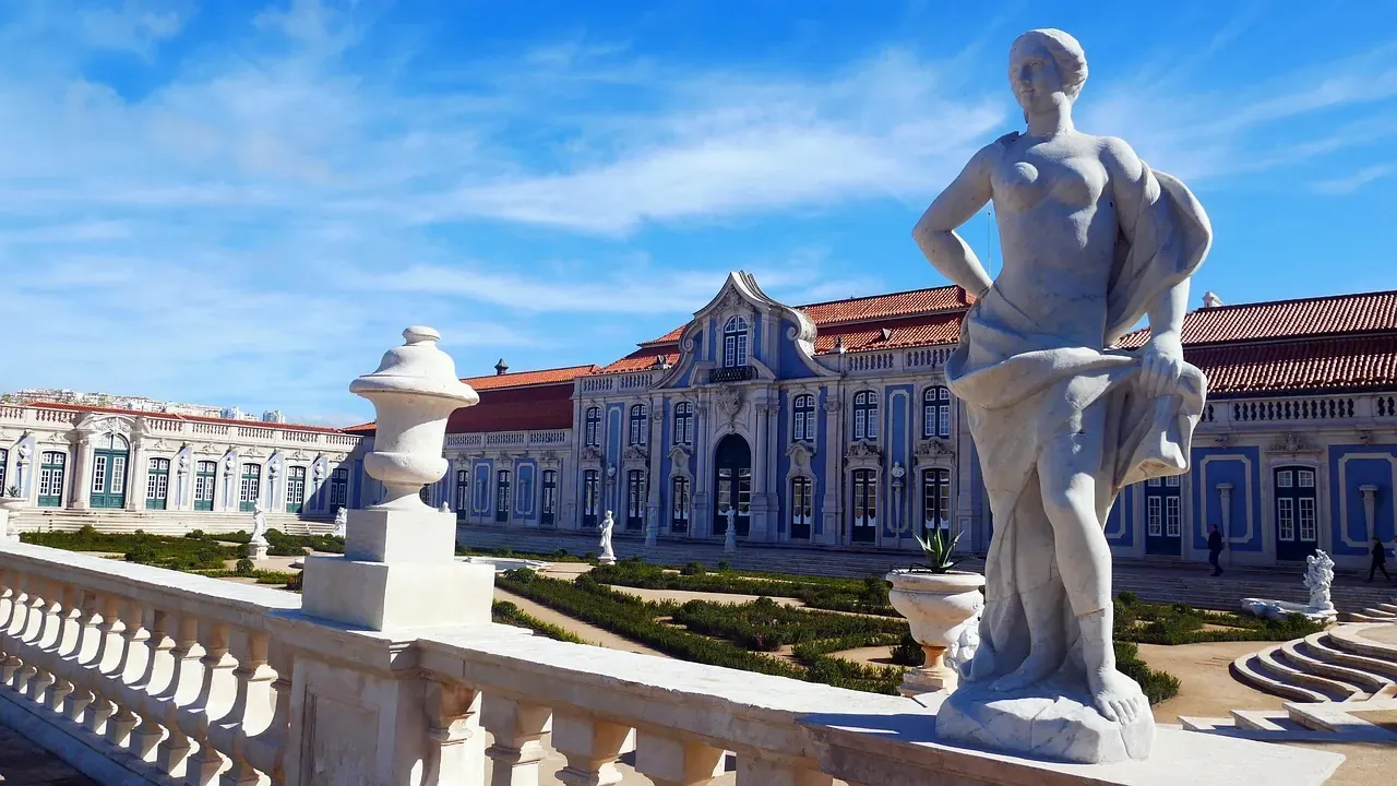 A garden statue before the rococo facade of Queluz National Palace