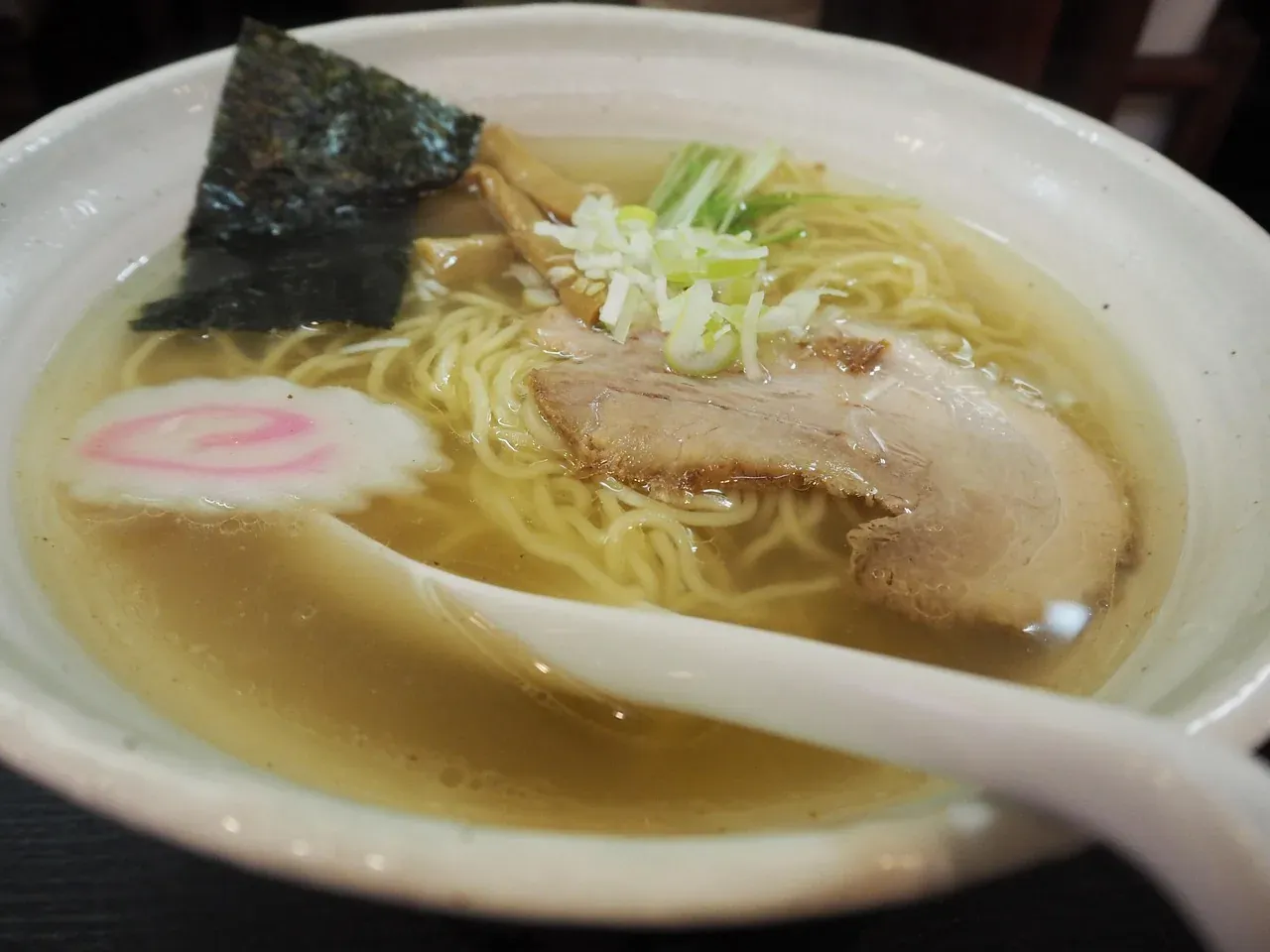 A bowl of ramen with sliced pork, narutomaki and nori