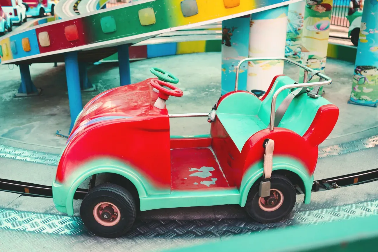 Red and green toy car on the track of a children's fairground ride