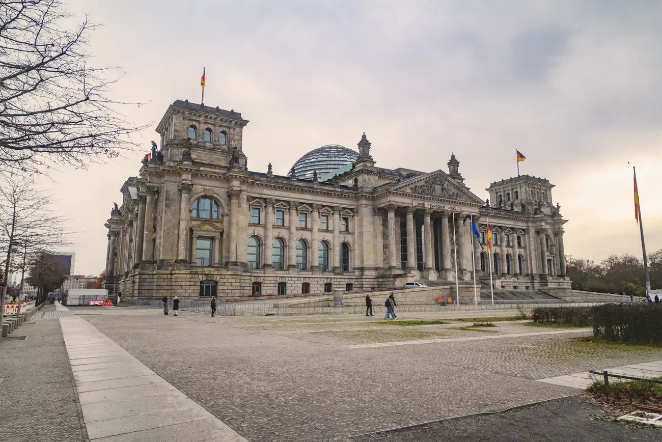 The Reichstag building in Berlin under a cloudy sky