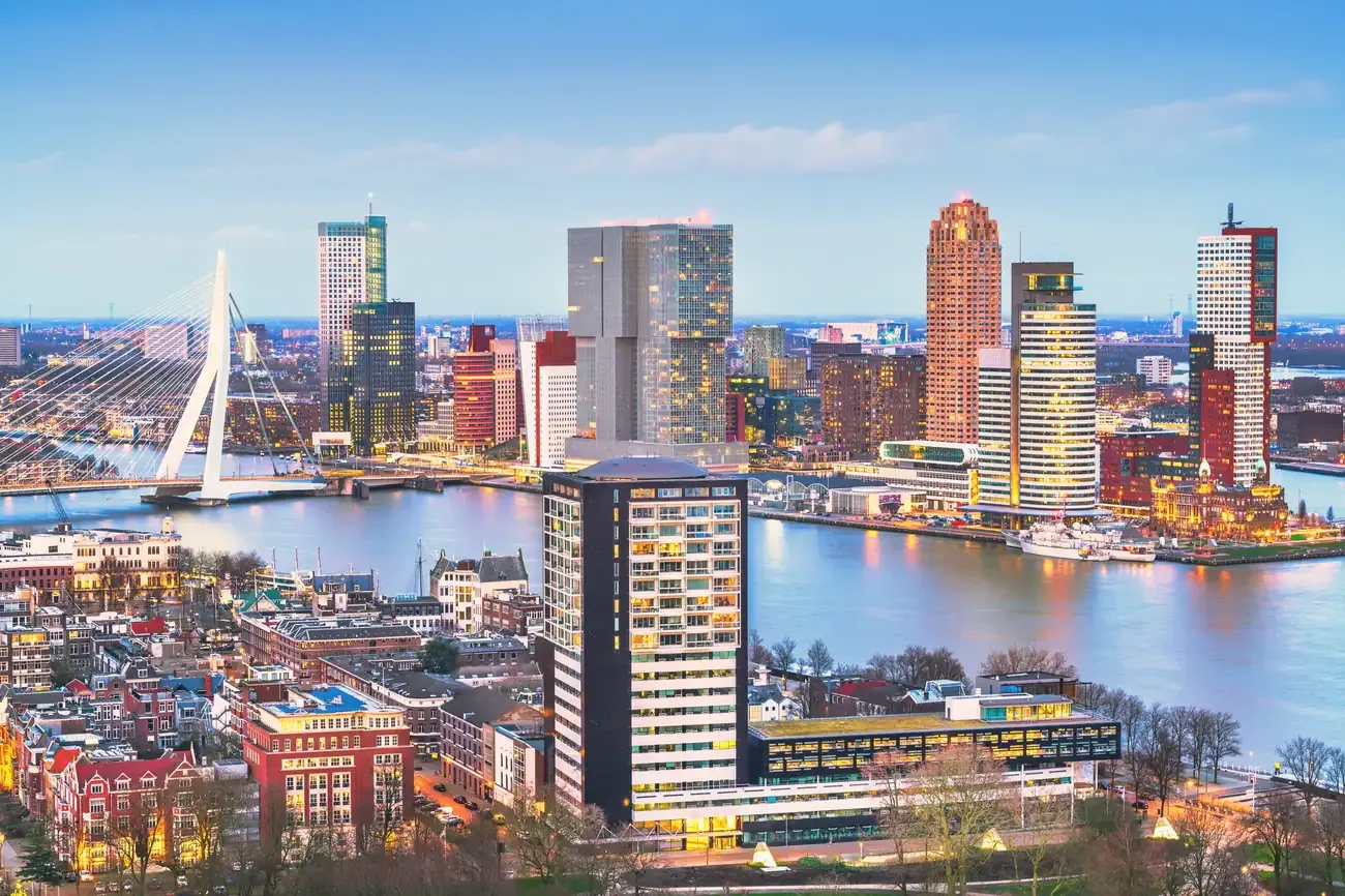 Aerial view of Rotterdam's modern skyline reflected in the Nieuwe Maas at twilight