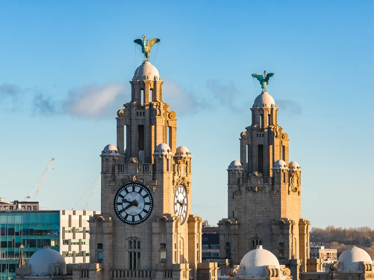 The twin clock towers of the Royal Liver Building topped by the Liver Birds at sunrise in Liverpool