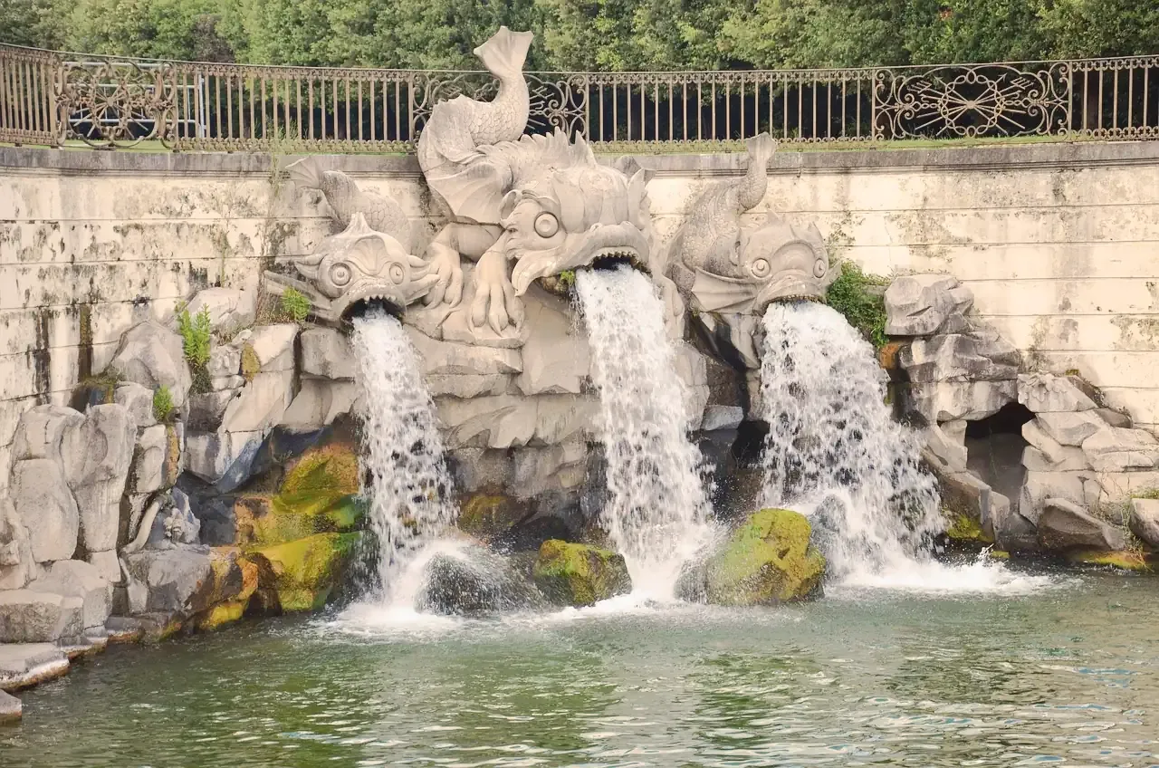 Sea-creature fountain sculptures spouting water into the garden canal at the Royal Palace of Caserta