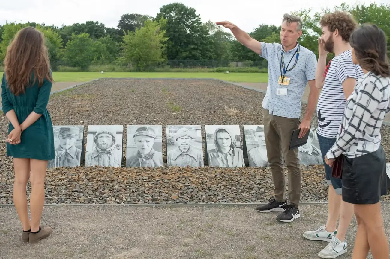 A guide explaining a memorial exhibit to visitors at Sachsenhausen Memorial