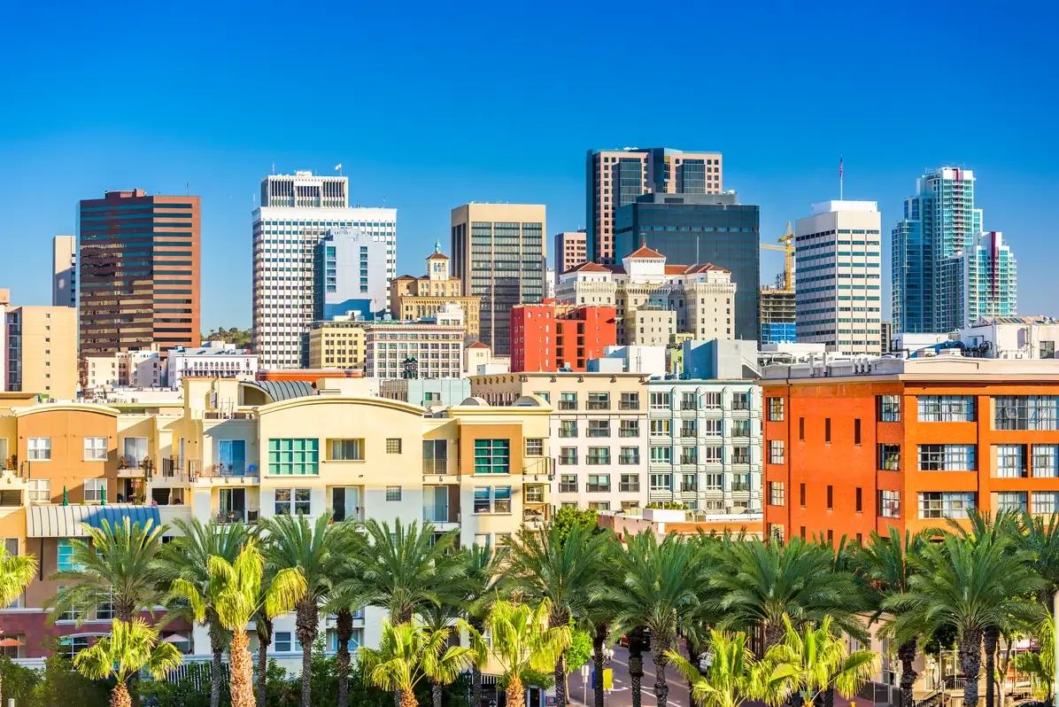 Downtown San Diego high-rises rising behind colourful low-rise apartment blocks and palm trees