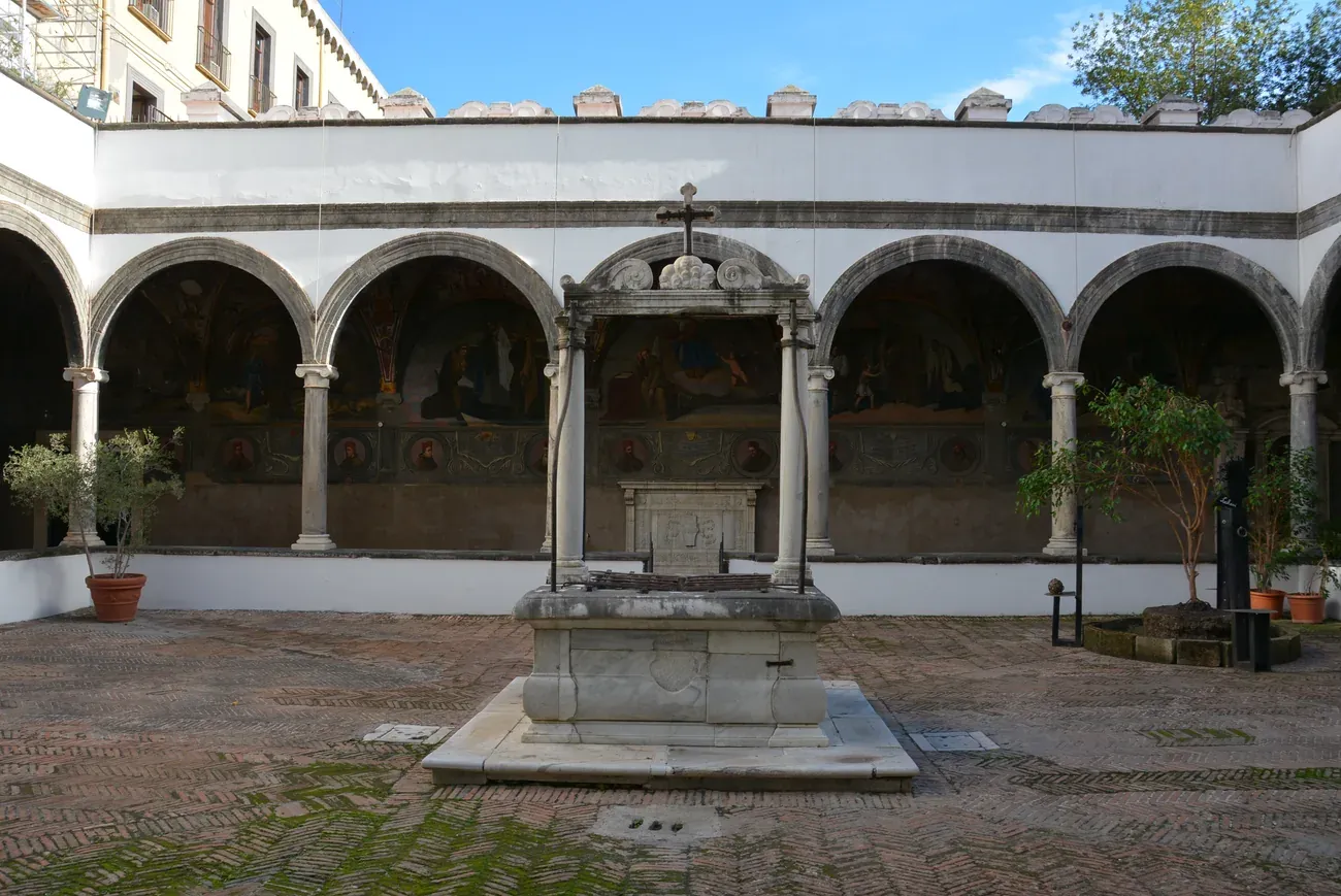 The small cloister of the church of Santa Maria la Nova in Naples, with a marble well and a frescoed arcade