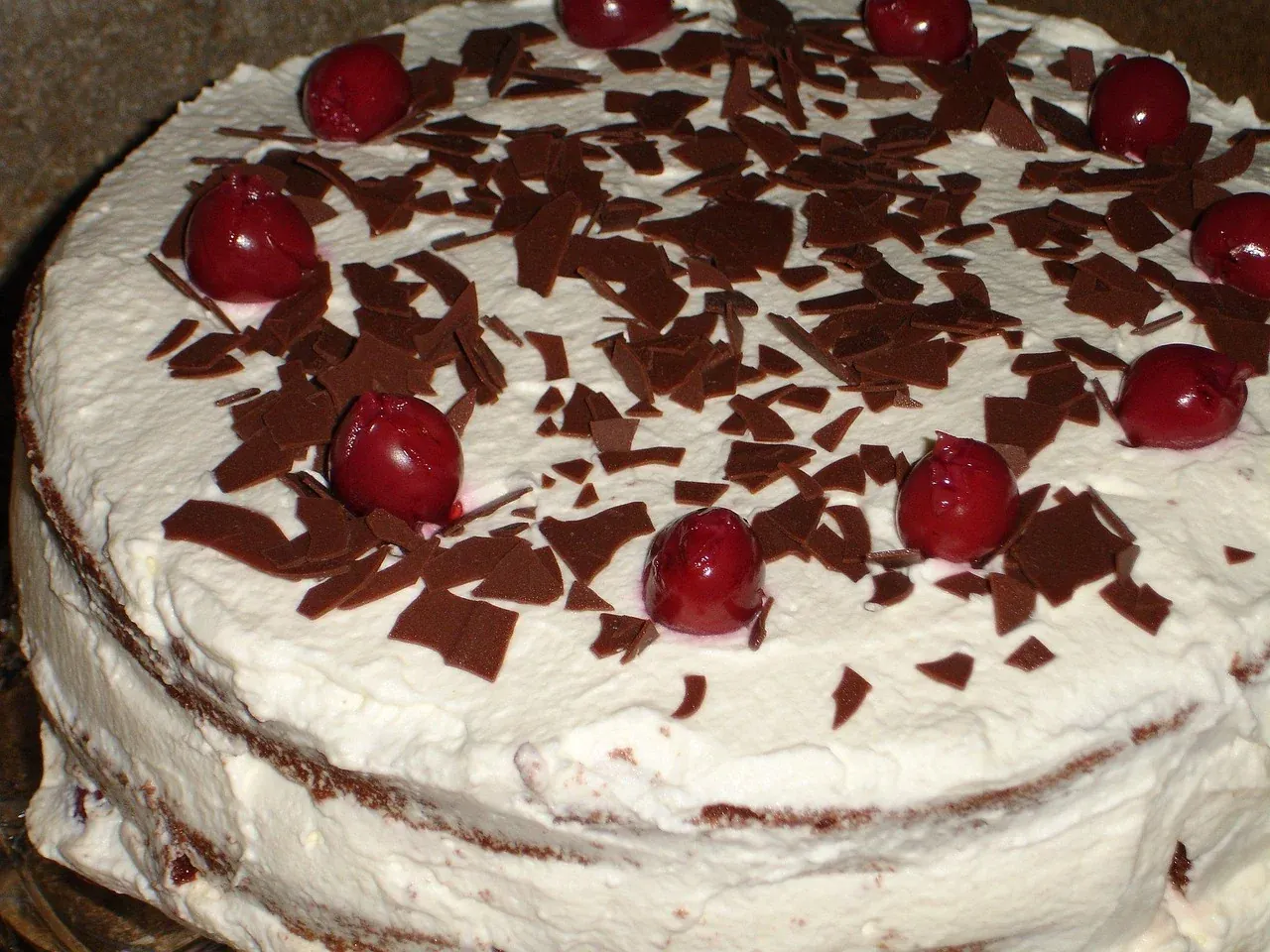 A whole Schwarzwälder Kirschtorte topped with cream, cherries and chocolate
