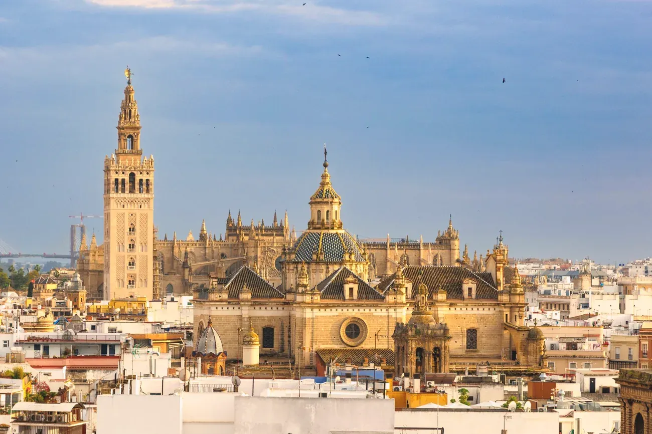 The Giralda tower and Seville Cathedral rising above the rooftops of Seville, Spain