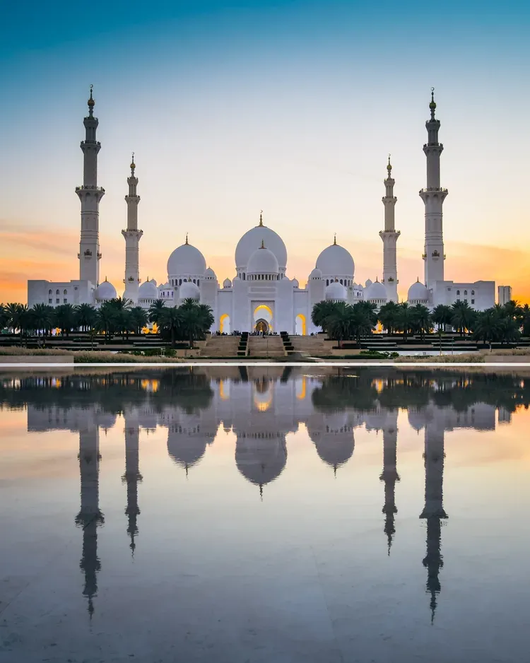 Sheikh Zayed Grand Mosque reflected in water at sunset, Abu Dhabi