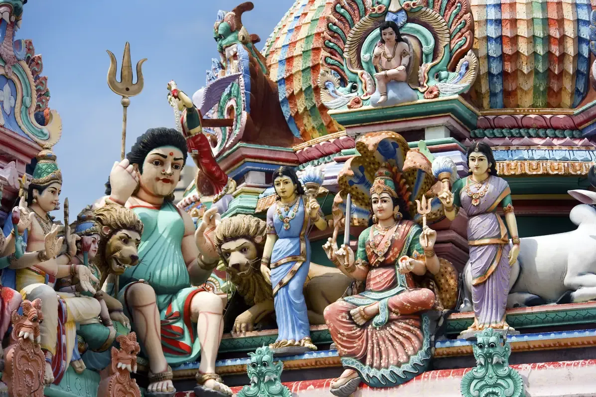 Brightly painted sculptures of Hindu deities, lions and a bull on the gopuram tower of a Hindu temple in Singapore