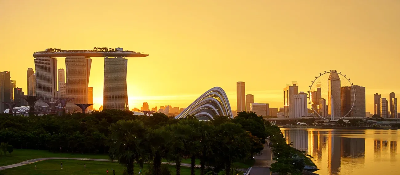 Marina Bay Sands, the Gardens by the Bay domes and the Singapore Flyer silhouetted against a golden sunset