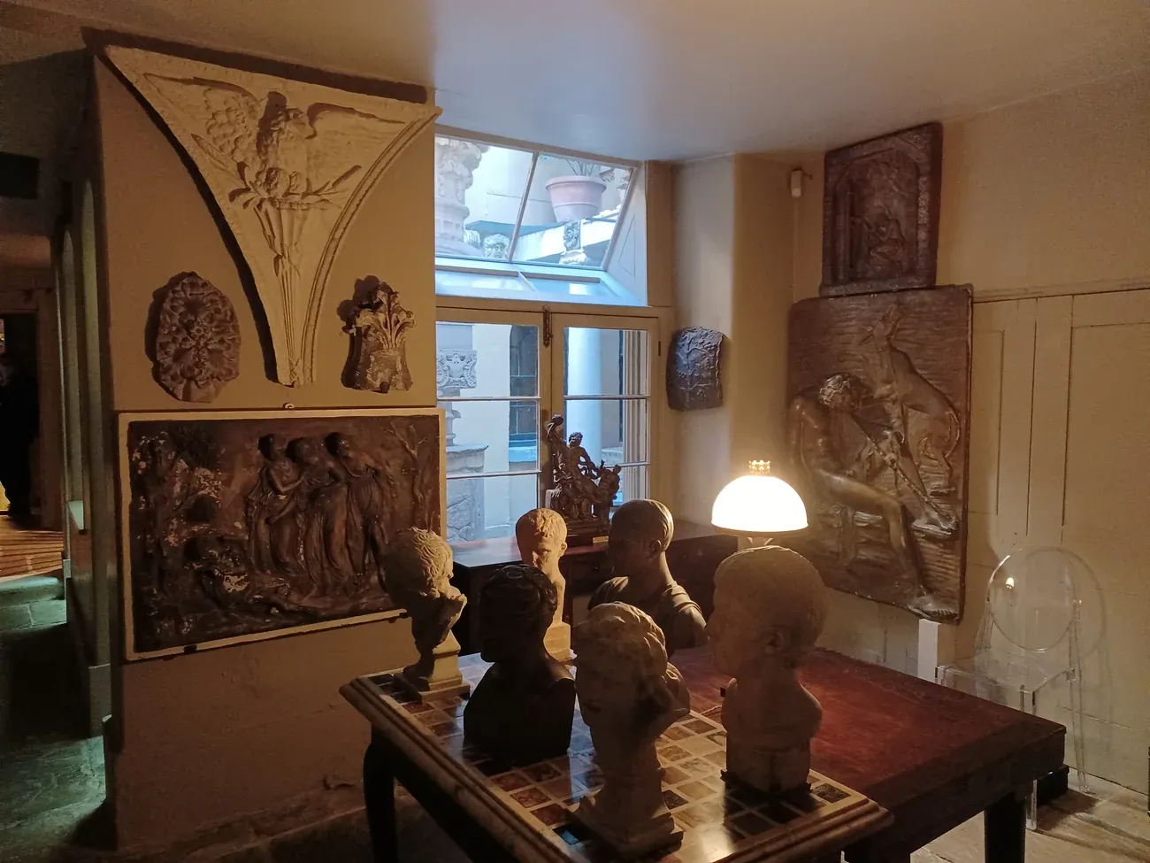 Busts, reliefs and a reading lamp in a room of Sir John Soane's Museum in London