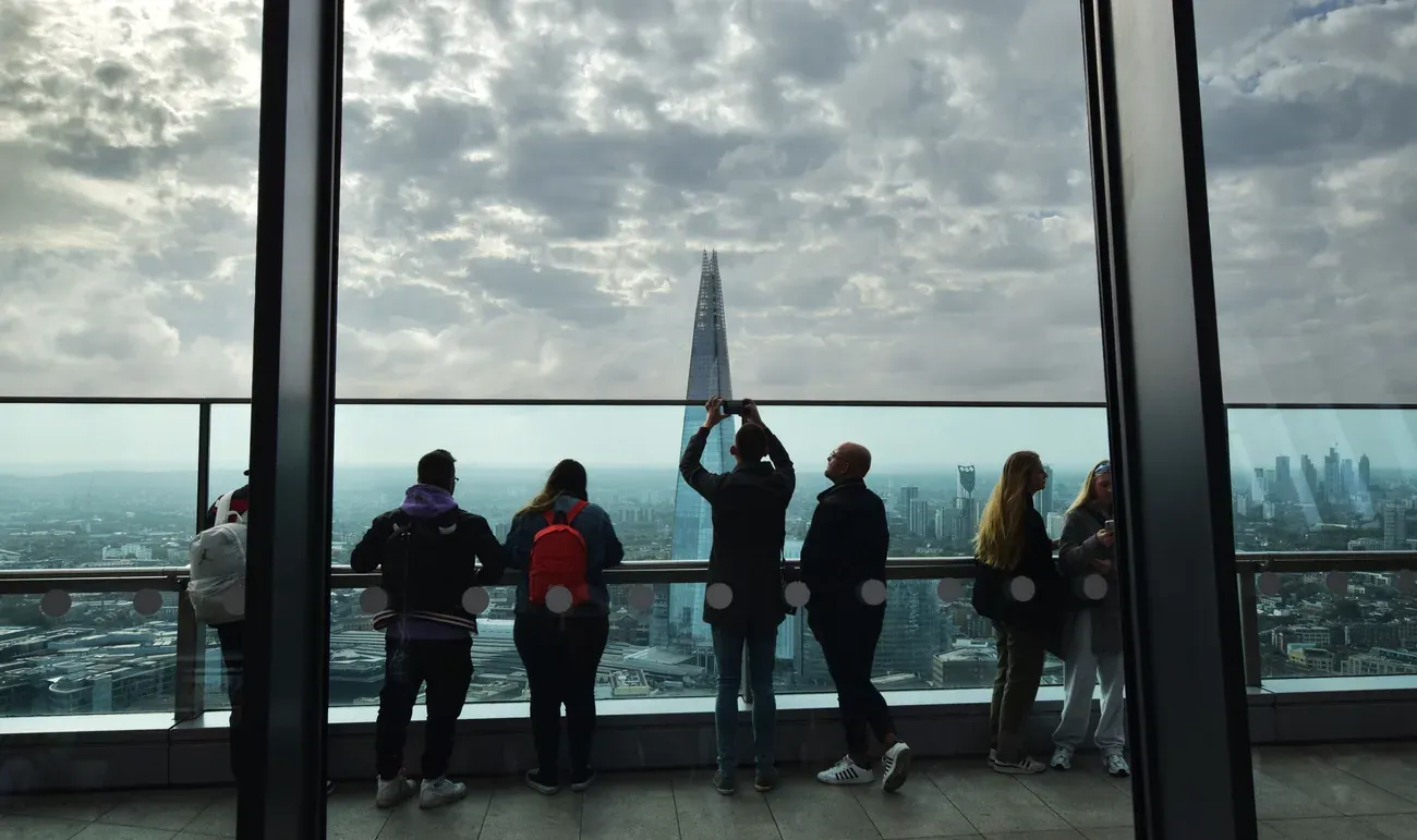 Visitors photographing the Shard through the glass wall of the Sky Garden in London