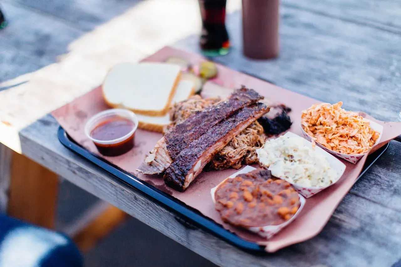 Smoked ribs and brisket served with sides on a barbecue tray