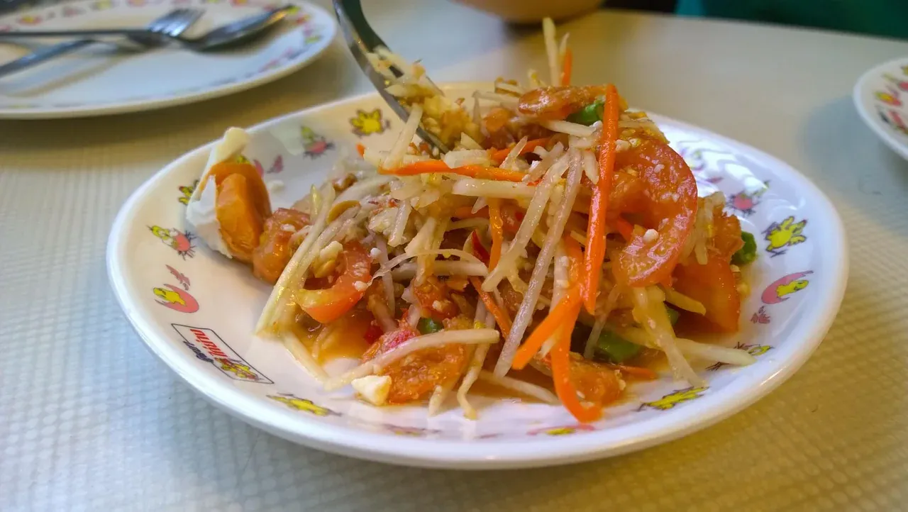 Som tam, the shredded green papaya salad, served on a plate