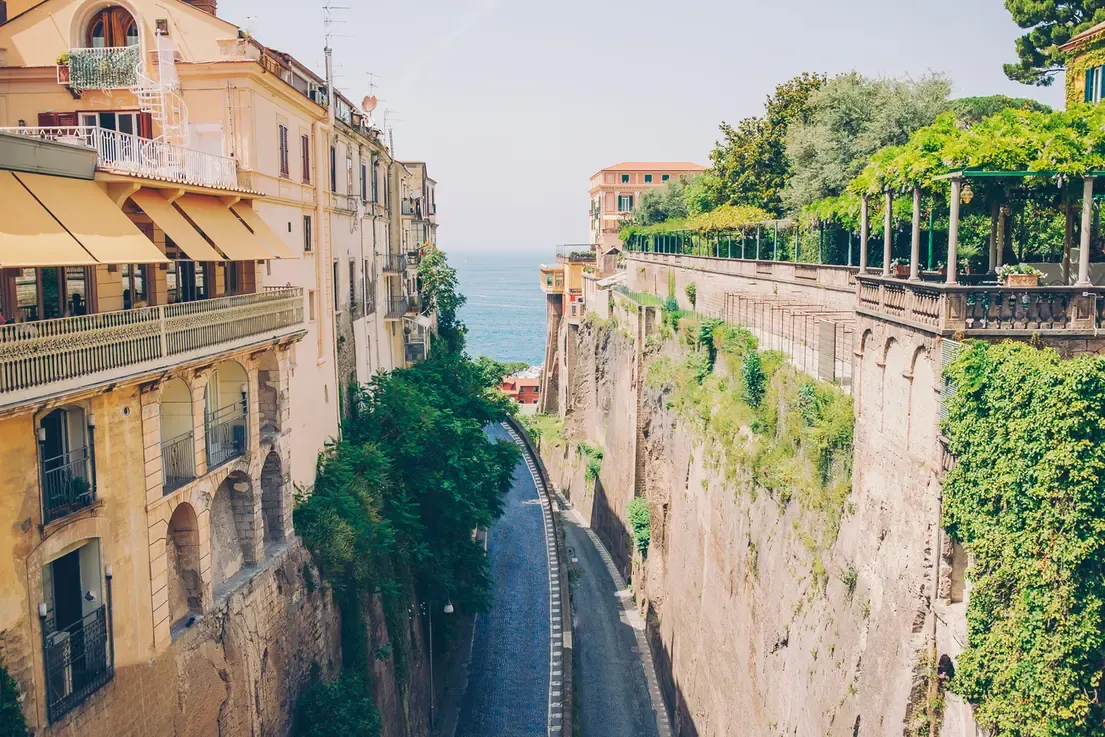 A narrow clifftop street in Sorrento opening onto a view of the sea