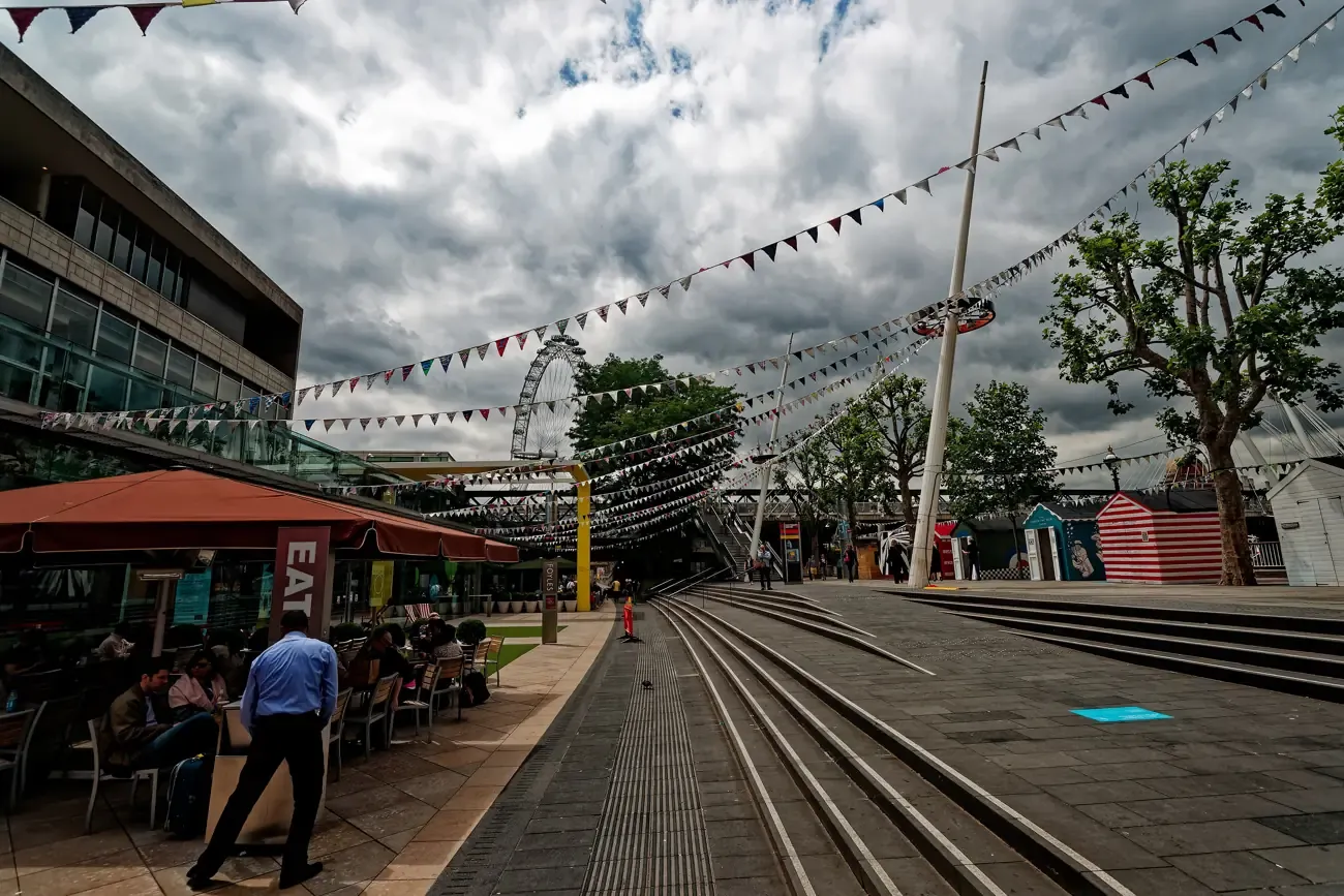 The South Bank riverside walk with bunting, with the London Eye beyond Hungerford Bridge