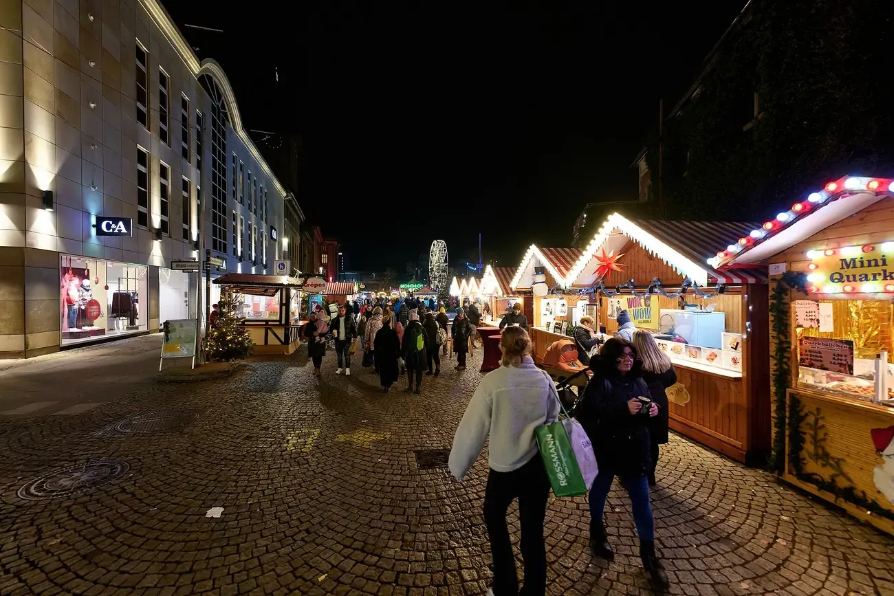 Lit stalls and shoppers in the pedestrian streets of Spandau old town during the Christmas market, Berlin