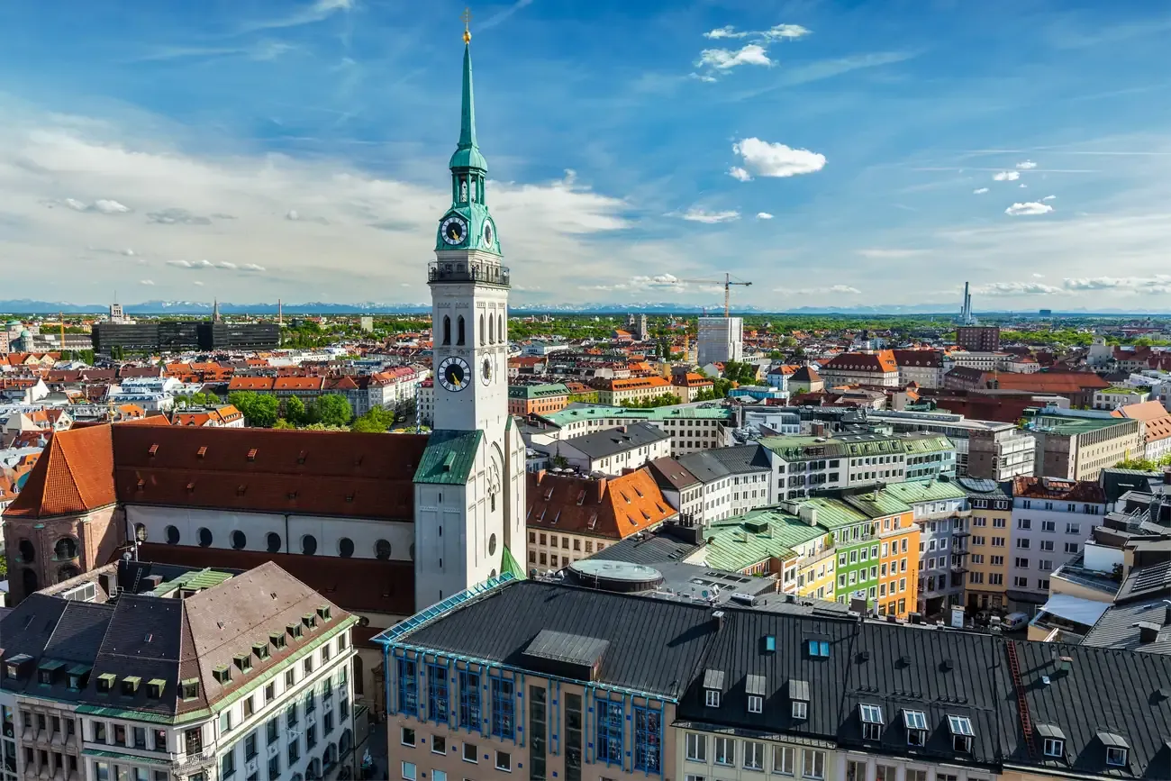 Aerial view of St Peter's Church and its tower in the old town of Munich with the Alps on the horizon