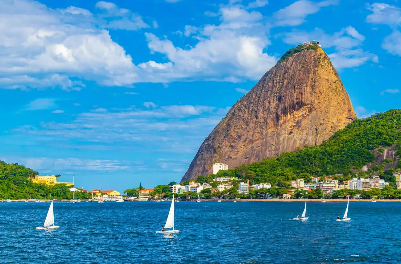 Sugarloaf Mountain rising above the bay with sailboats in the foreground at Urca, Rio de Janeiro.