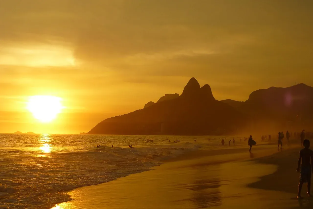 The sun setting behind the Dois Irmaos peaks seen from Ipanema beach