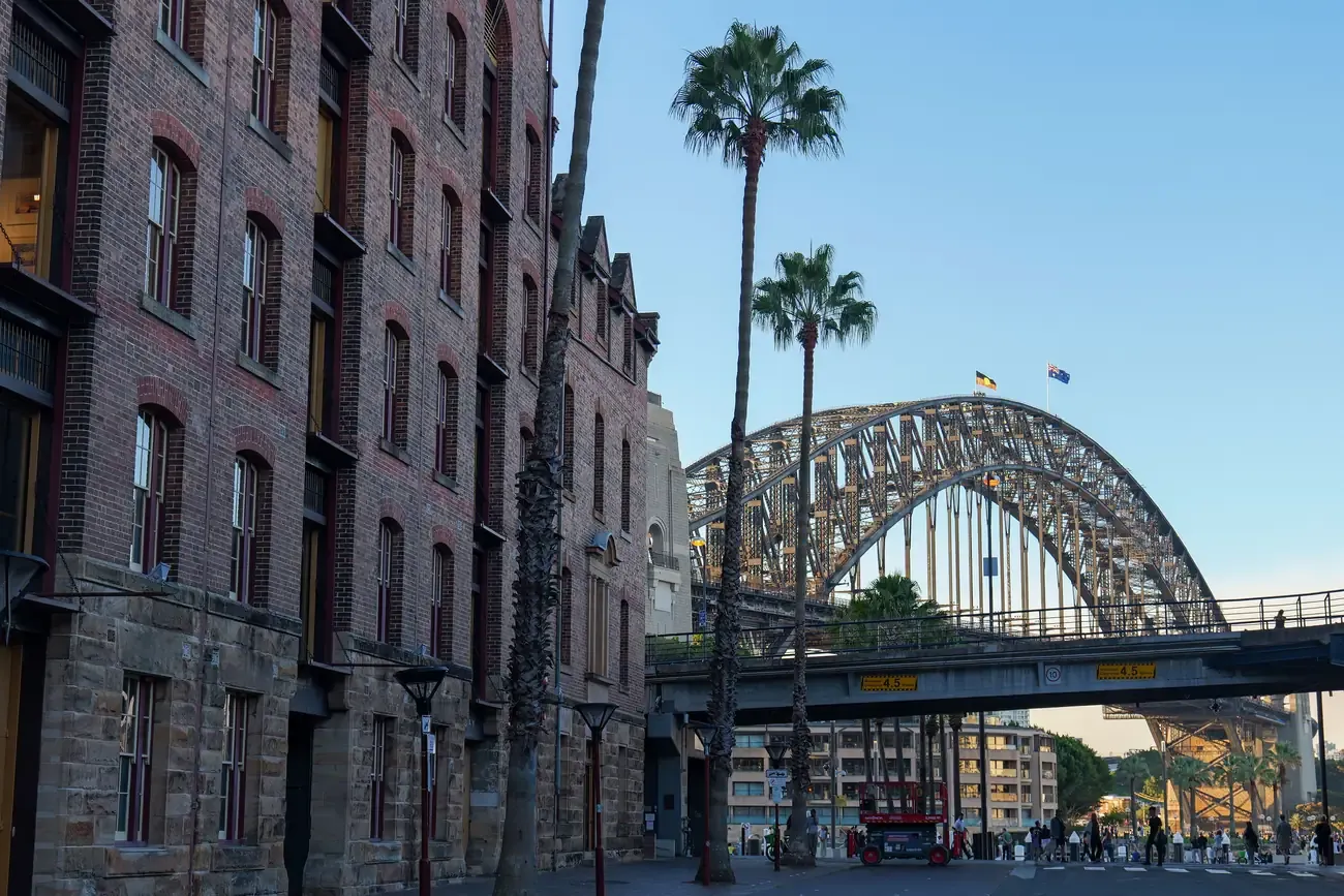 A historic street in The Rocks with the Sydney Harbour Bridge behind