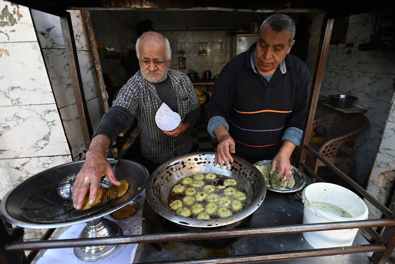 Green ta'meya patties frying at a street stall in Cairo