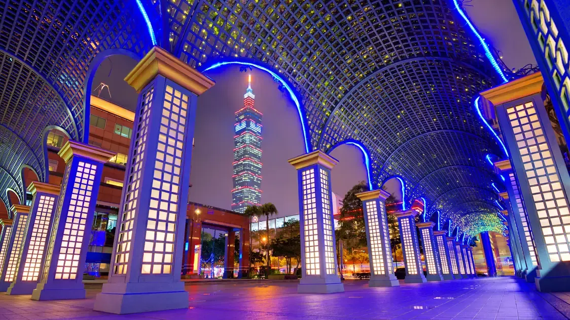 Taipei 101 seen through a blue-lit pergola at night